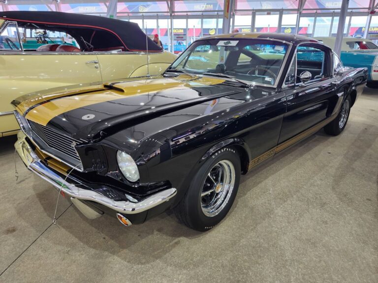 Front three-quarter view of a black and gold 1966 Shelby GT350H "Hertz Rent-A-Racer" parked at Mecum Kissimmee 2026