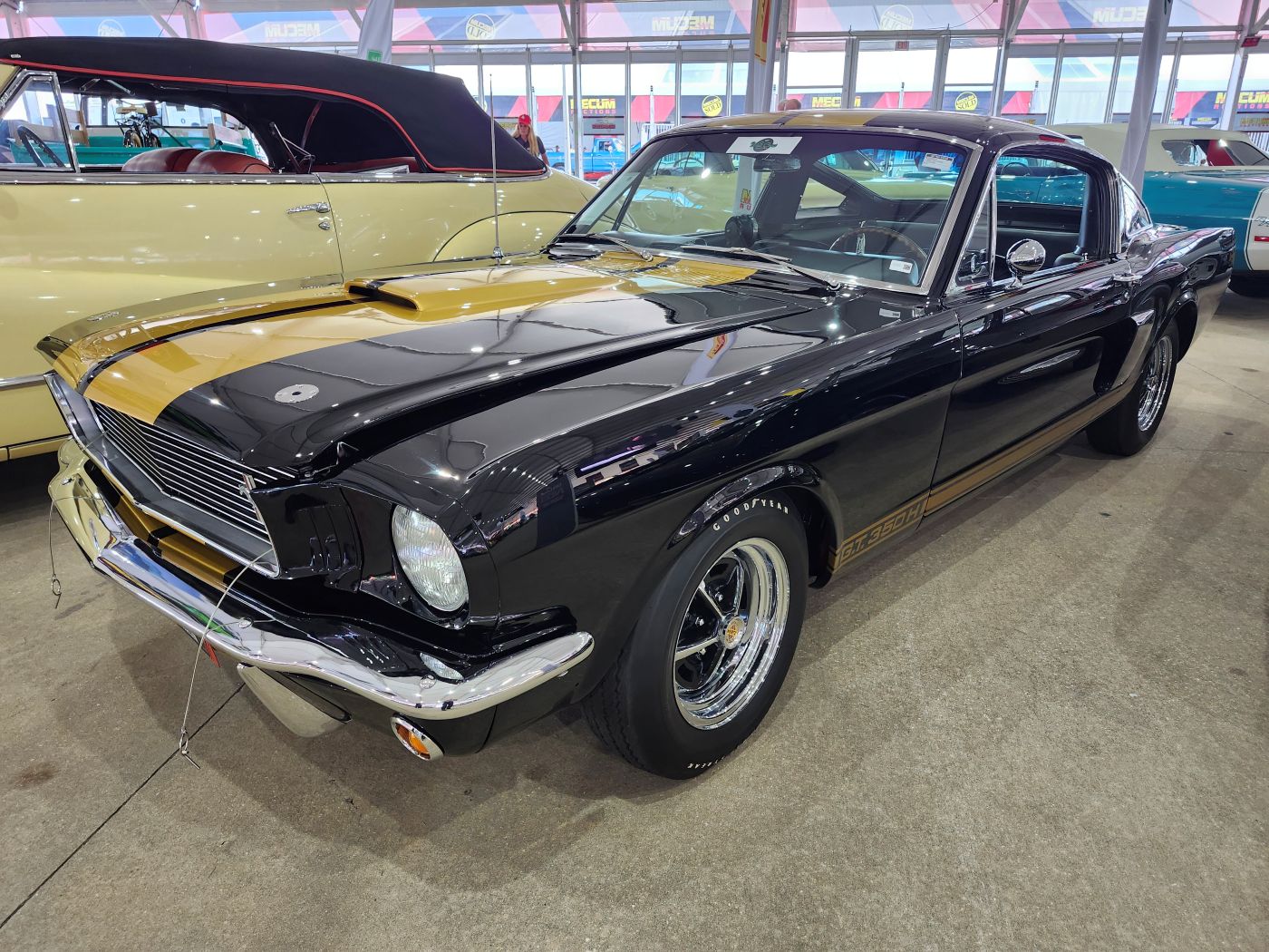 Front three-quarter view of a black and gold 1966 Shelby GT350H "Hertz Rent-A-Racer" parked at Mecum Kissimmee 2026