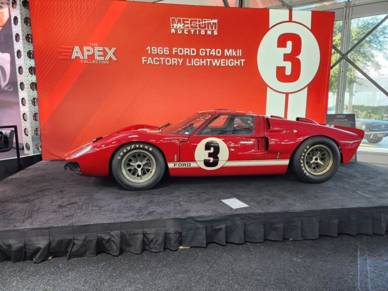 Profile view of a red #3 1966 Ford GT40 MkII Factory Lightweight displayed on the Mecum Kissimmee 2026 auction stage.
