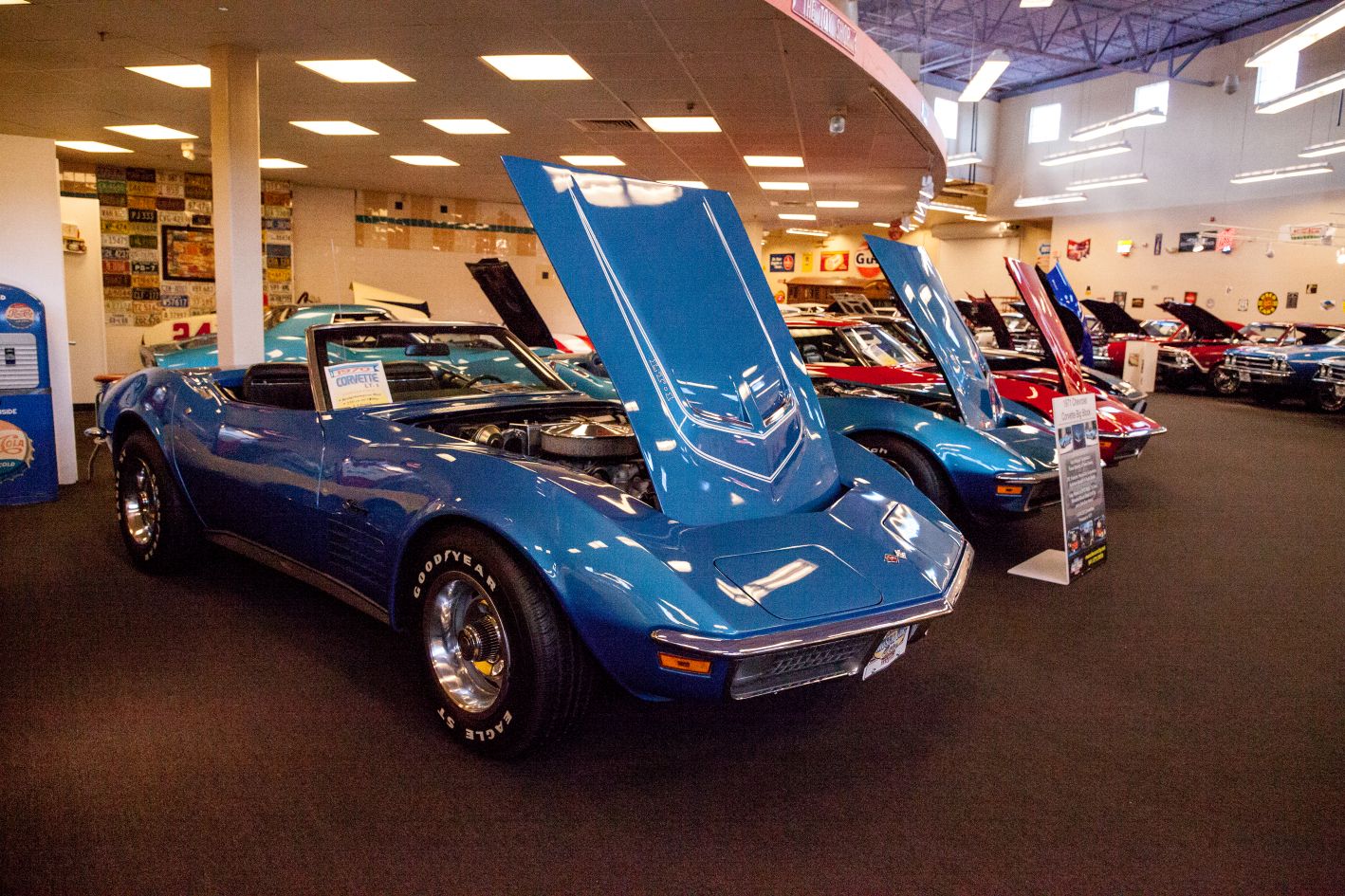 Collector vehicles displayed during a professional appraisal review in an indoor exhibition setting