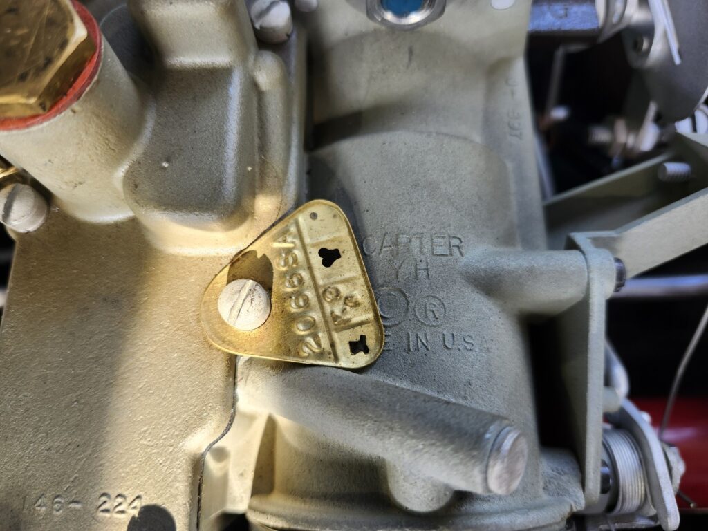 Close-up of the Carter carburetor tag showing model number 2066SA on a 1953 Corvette triple-carburetor setup.