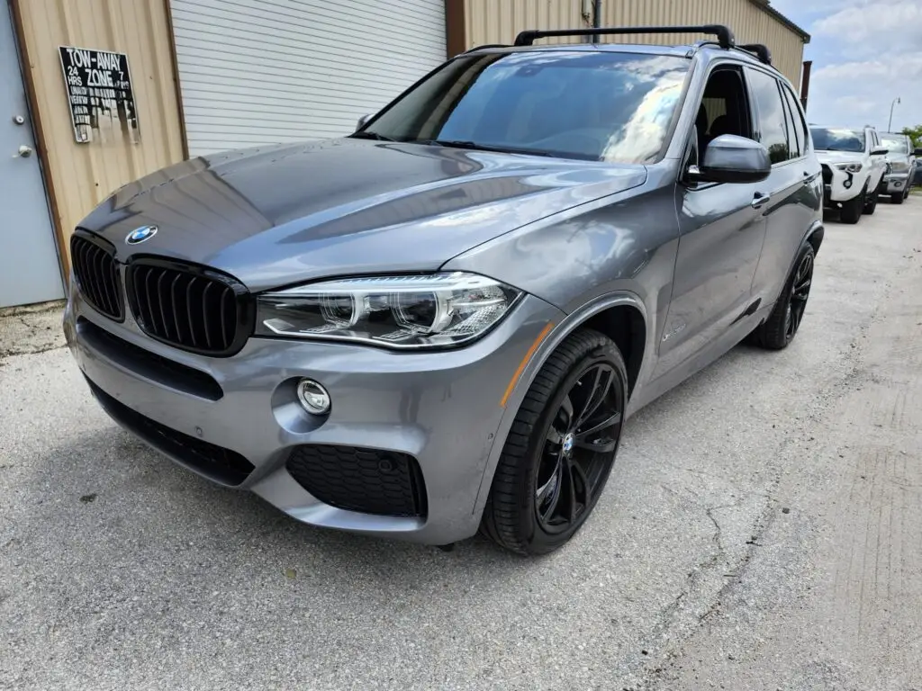 Front-angle inspection of a grey BMW X5 for a diminished value appraisal Weston Florida to document market loss after a collision.
