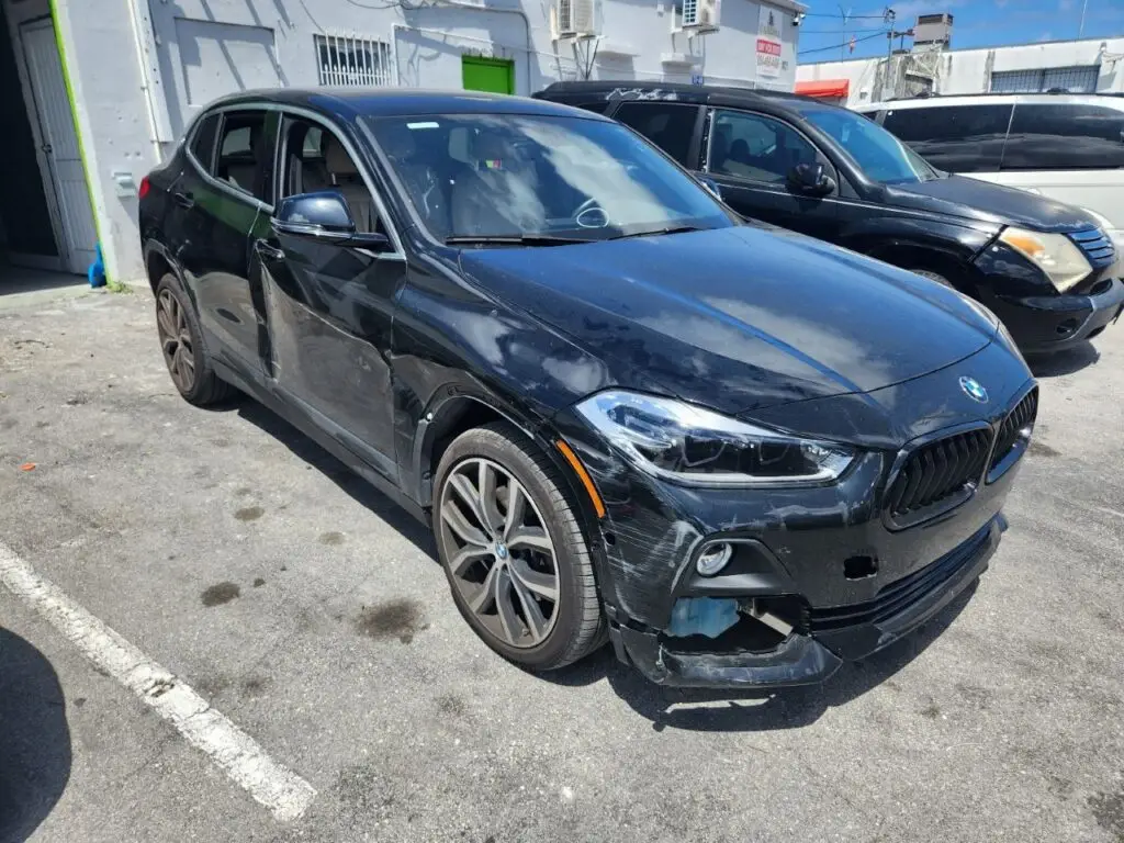 Detailed inspection of side and front-end damage on a BMW X2 as part of a comprehensive diminished value appraisal West Palm Beach Florida.