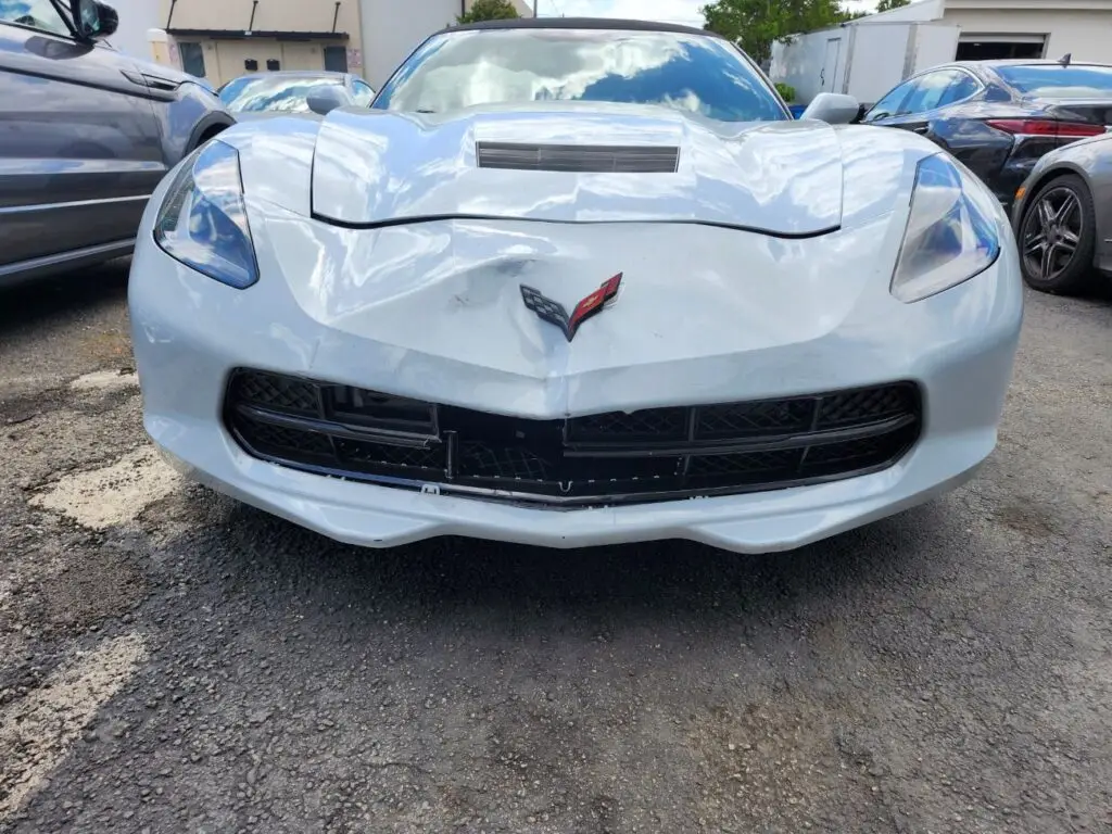 Documenting front bumper and hood impact on a Chevrolet Corvette for a specialized diminished value appraisal Pembroke Pines performance vehicle report.
