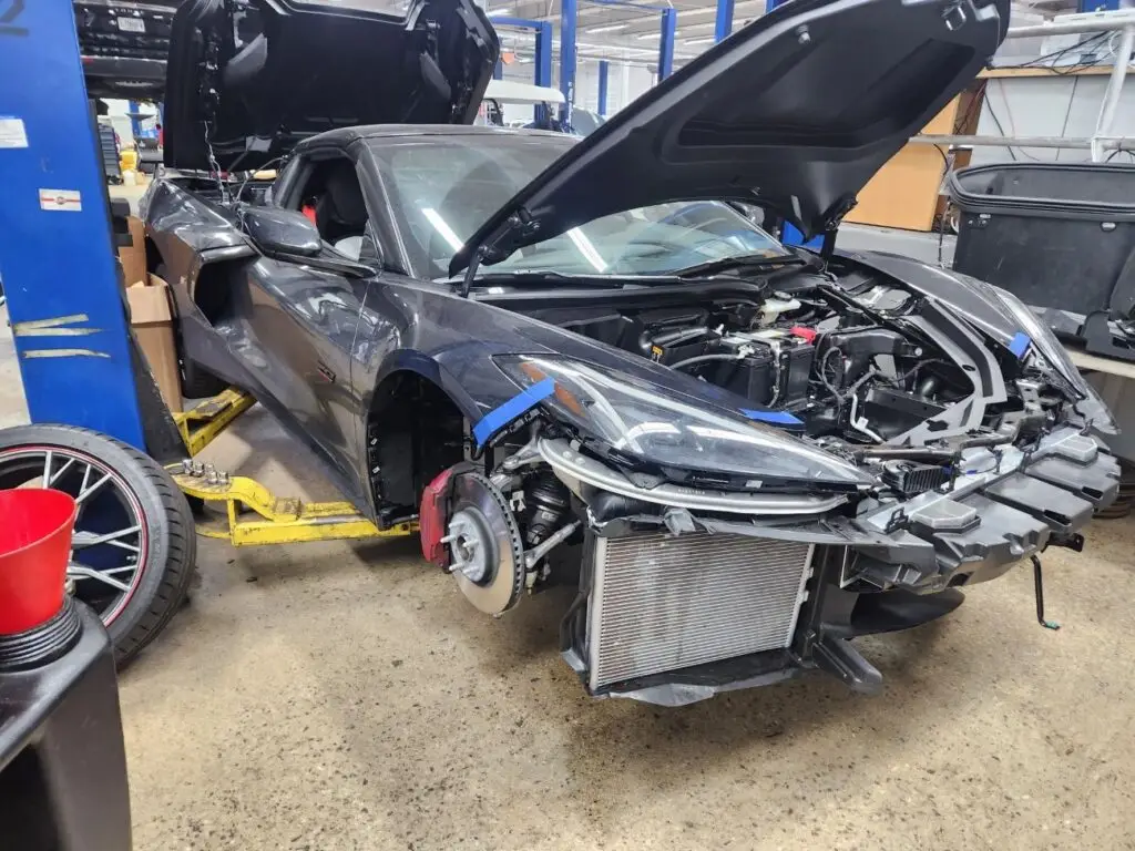 Structural and mechanical inspection of a grey Chevrolet Corvette C8 on a lift for a diminished value appraisal in Parkland Florida.