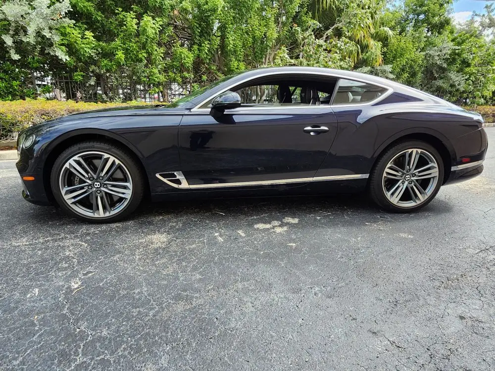 Side-profile market assessment of a dark blue Bentley Continental GT for a specialized diminished value appraisal in Boynton Beach.