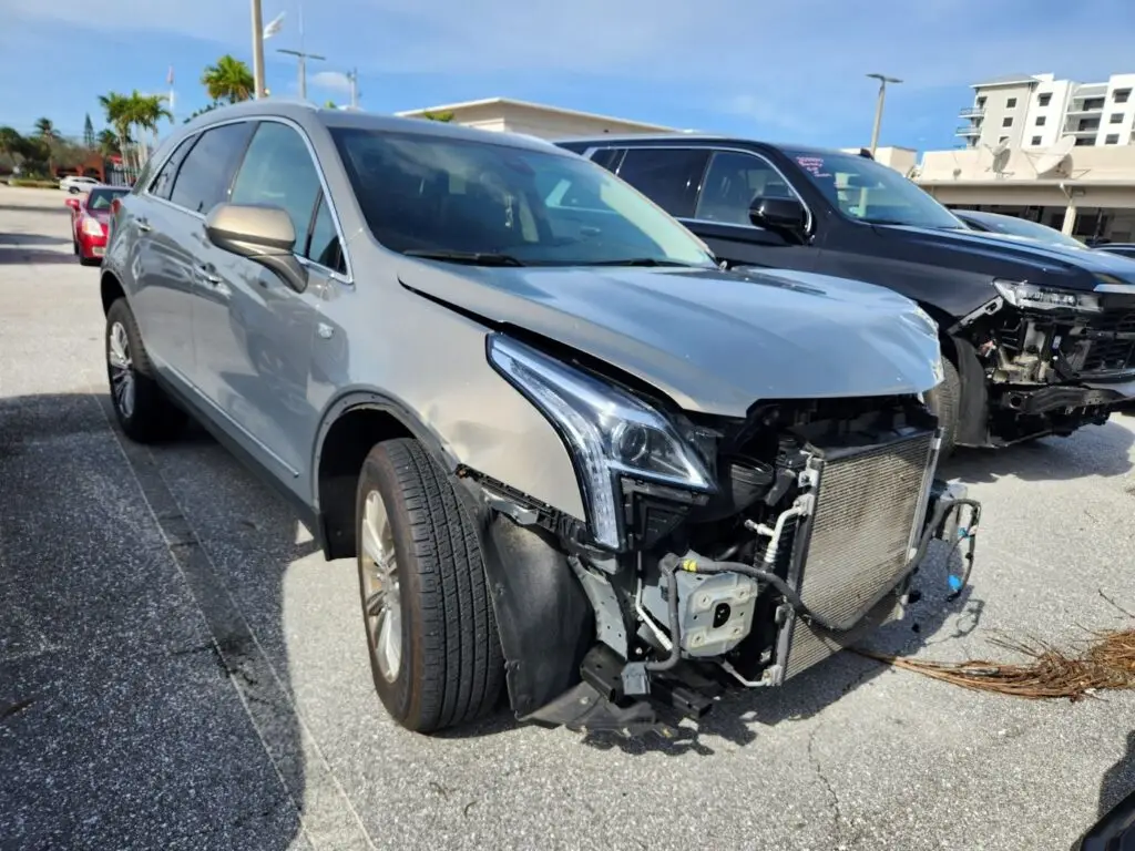 Assessing front-end collision impact on a silver Cadillac XT5 for a diminished value appraisal in Boynton Beach Florida.