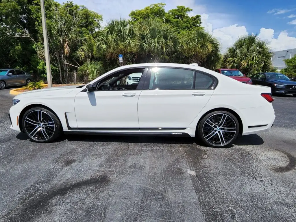 Side-profile market assessment of a white BMW 7 Series performance sedan for a certified diminished value appraisal in Coconut Creek.