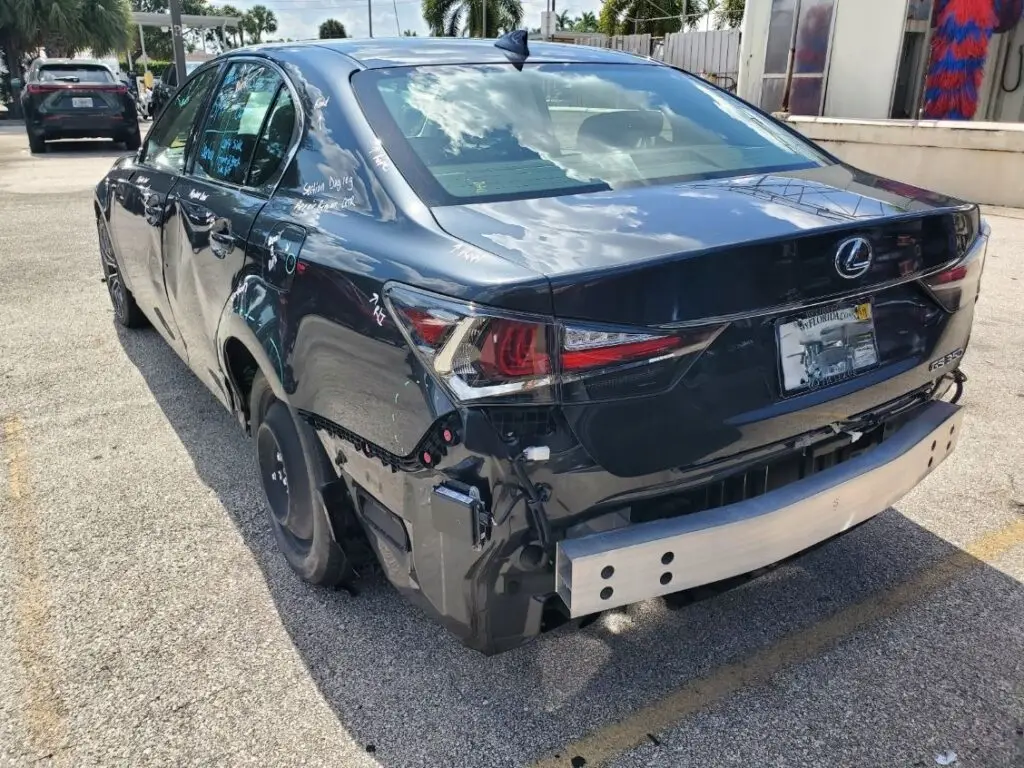 Assessing rear-end structural damage on a dark blue Lexus GS350 for a diminished value appraisal in Coconut Creek Florida.