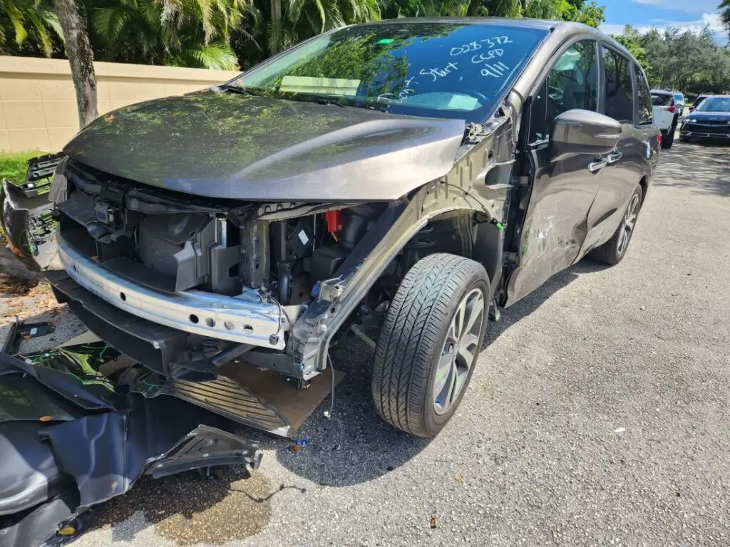 Documenting front-end structural repairs on a bronze Honda Odyssey for a professional diminished value appraisal report in Delray Beach.