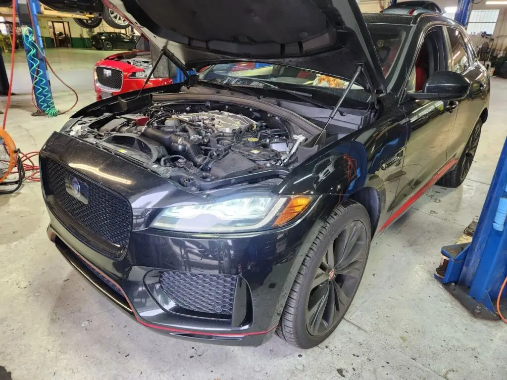 Assessing front-end collision and engine bay repairs on a black 2019 Jaguar F-PACE for a diminished value appraisal Fort Myers Florida.