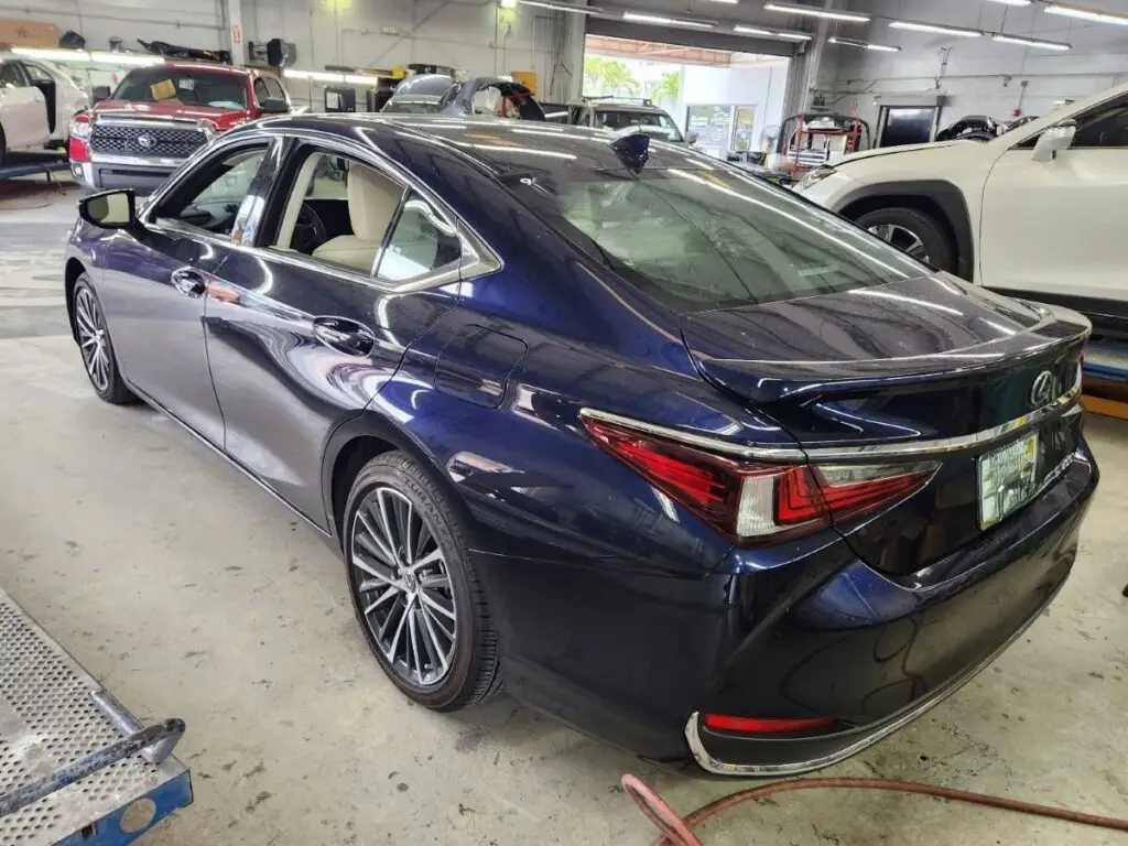 This image of a 2023 Lexus ES 300 in a certified collision center demonstrates that inherent diminished value begins the moment a high-end vehicle’s history report changes, despite the high quality of the repairs shown.