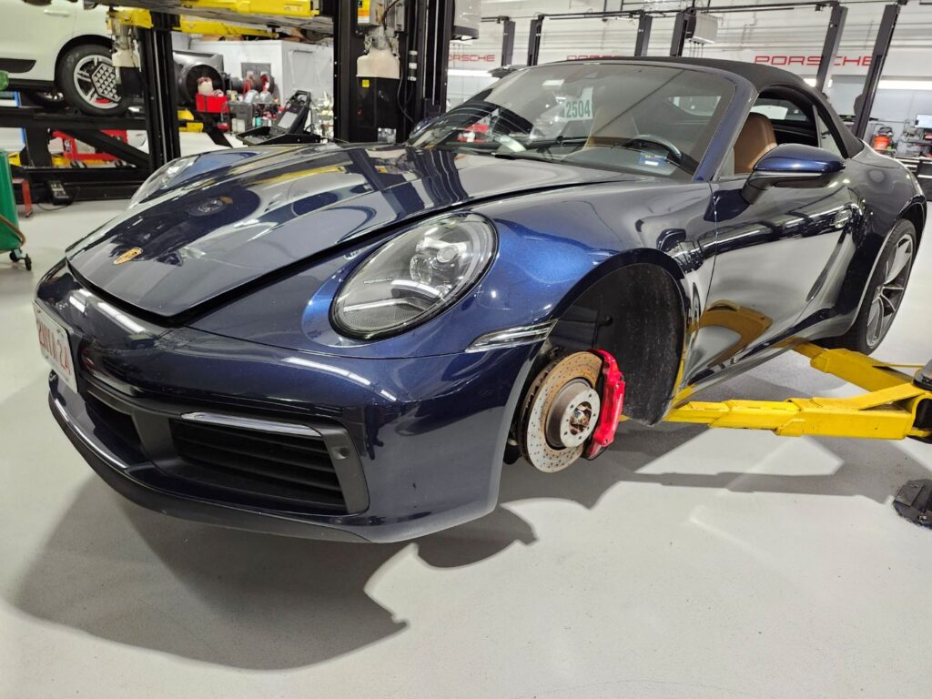 Professional audit of front end structural and cosmetic repairs on a blue 2024 Porsche 911 Carrera for a diminished value appraisal in Miami Gardens.