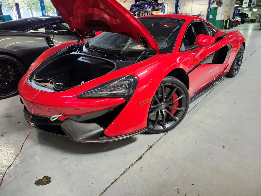 Documenting the market impact of front-end collision repairs on a red 2018 McLaren 570S for a diminished value appraisal Naples.