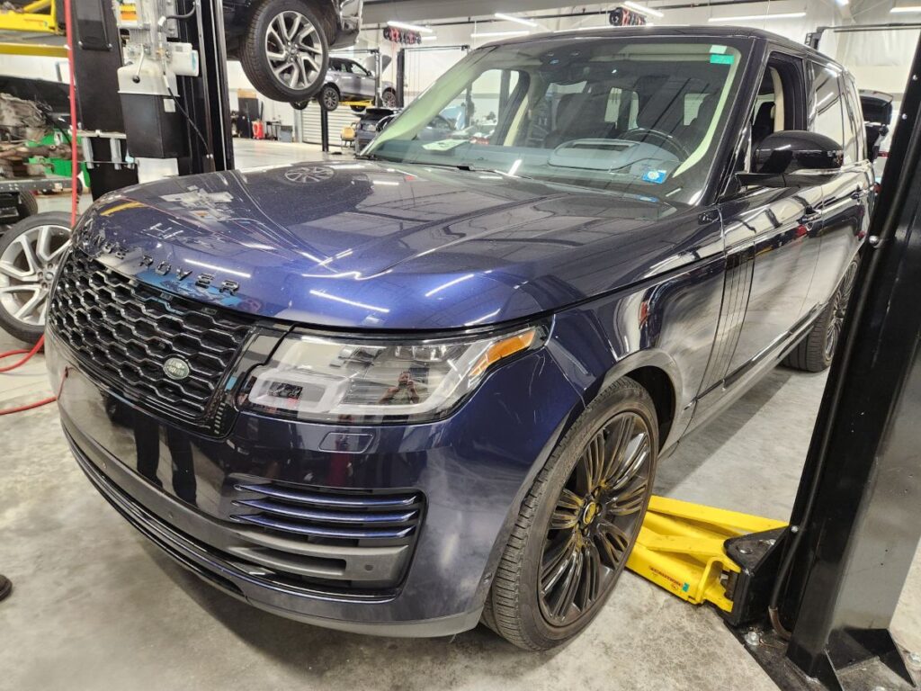 Assessing undercarriage and structural repairs on a blue 2021 Land Rover Range Rover for a diminished value appraisal in Palm Beach Gardens Florida.