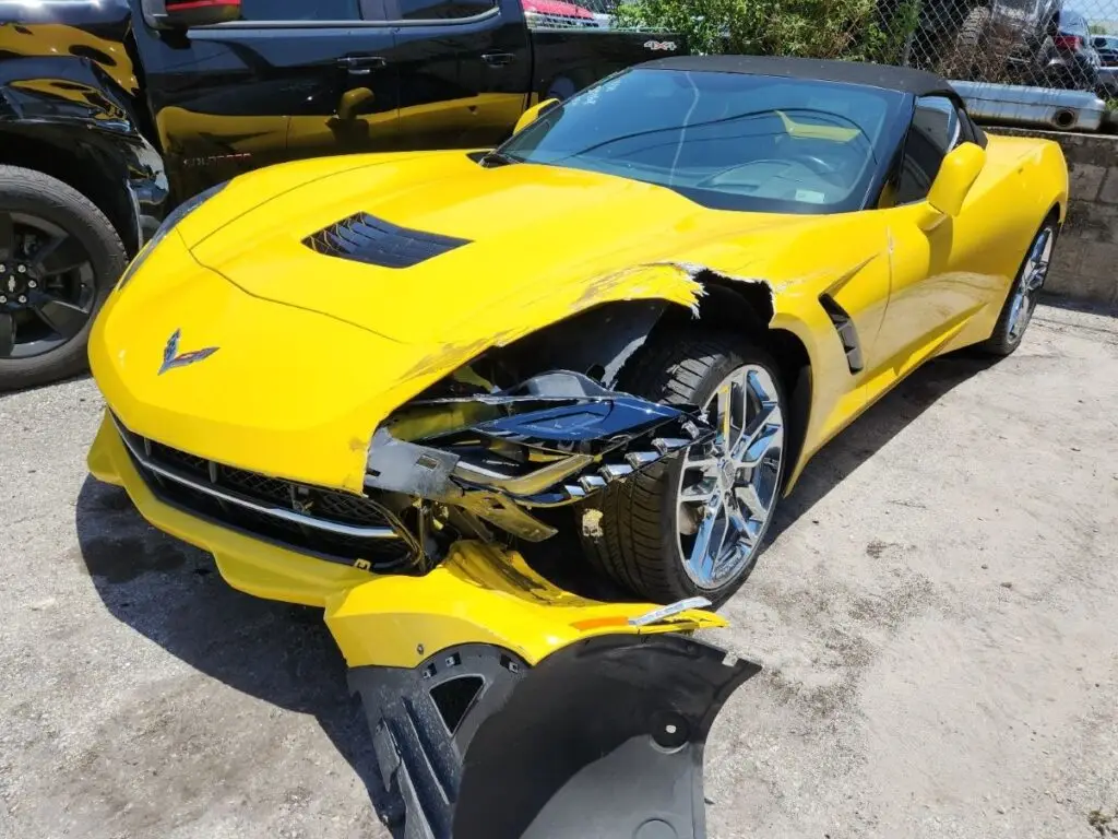 Evaluating severe front-end and fender impact on a yellow Chevrolet Corvette C7 for a certified diminished value appraisal in Plantation Florida.