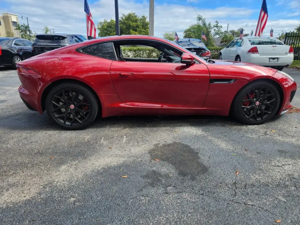 Side-profile market assessment of a red Jaguar F-Type coupe for a specialized diminished value appraisal in Royal Palm Beach Florida.