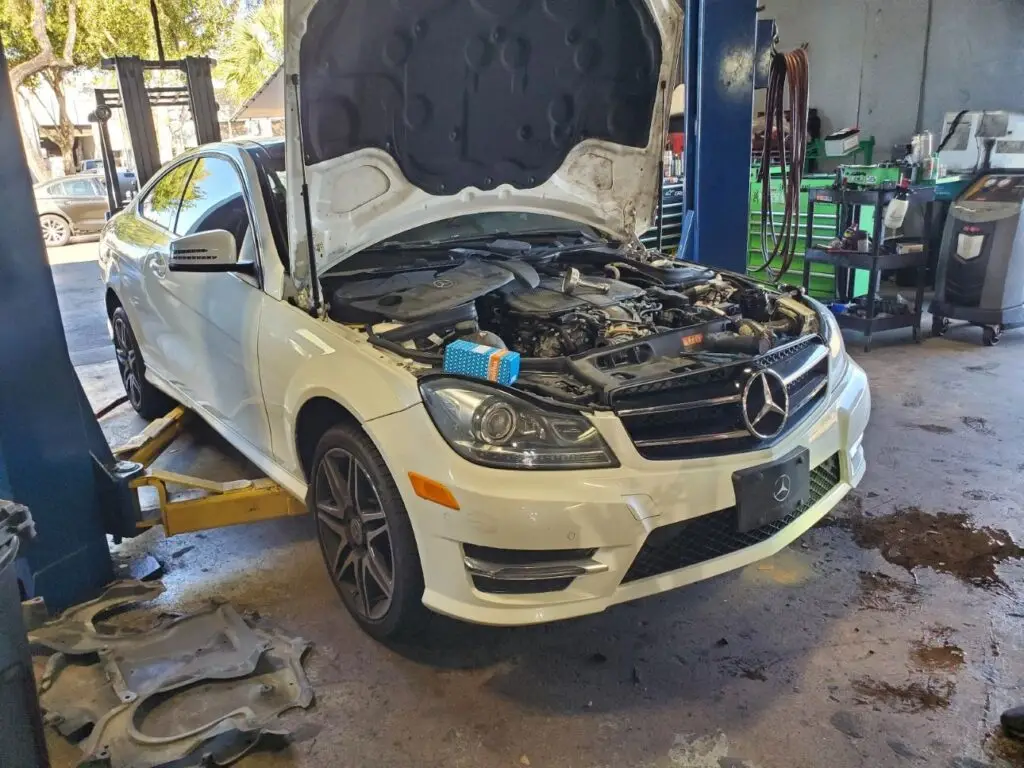Assessing front-end collision and engine bay repairs on a white 2016 Mercedes-Benz C350 for a diminished value appraisal Tampa.