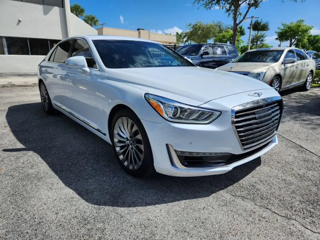 Auto Praise conduction a detailed inspection of a white Genesis G90 luxury sedan for an independent diminished value appraisal in Hollywood Florida.