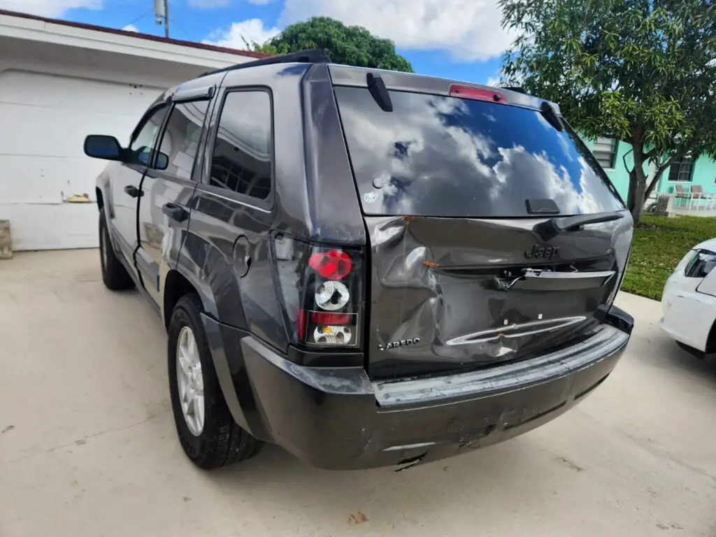 Assessing significant liftgate and rear bumper damage on a charcoal Jeep Grand Cherokee for a diminished value appraisal in Hialeah.