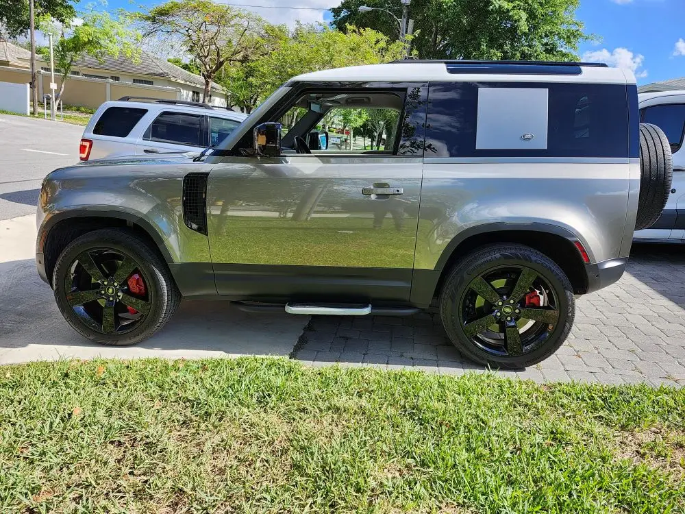 Side-profile assessment of a late-model Land Rover Defender 90 during a diminished value appraisal in Wellington Florida to evaluate market loss after collision repairs.