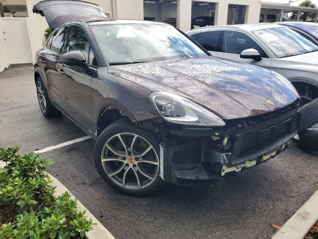 Documenting significant front-end collision repairs on a dark Porsche Macan for a diminished value appraisal in Parkland Florida.