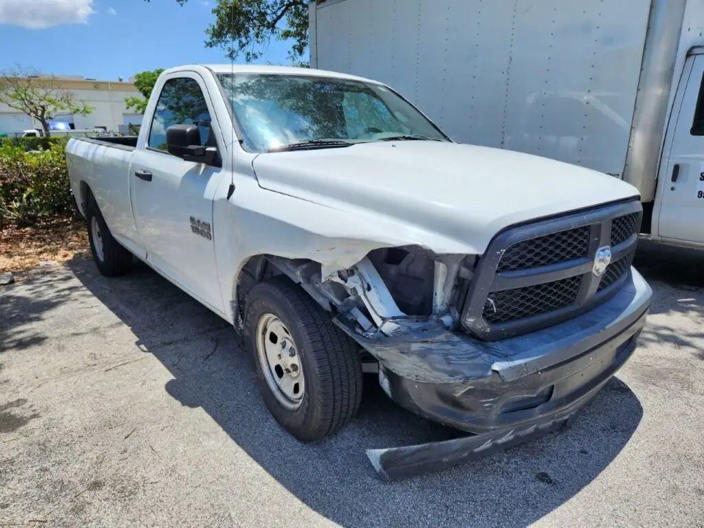 Evaluating front fender and headlight damage on a RAM 1500 for an accurate diminished value appraisal Davie Florida.