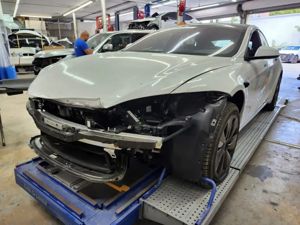 Technical structural inspection of a Tesla Model 3 in a certified repair facility for a diminished value appraisal Davie Florida.