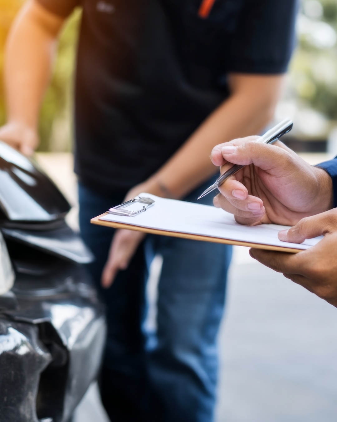 insurance adjuster documenting vehicle damage for diminished value claim