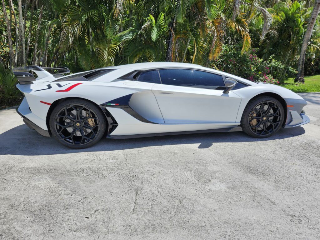 A side profile of a 2019 Lamborghini Aventador SVJ undergoing an independent total loss appraisal by Auto Praise in Miami to verify bespoke carbon fiber options.