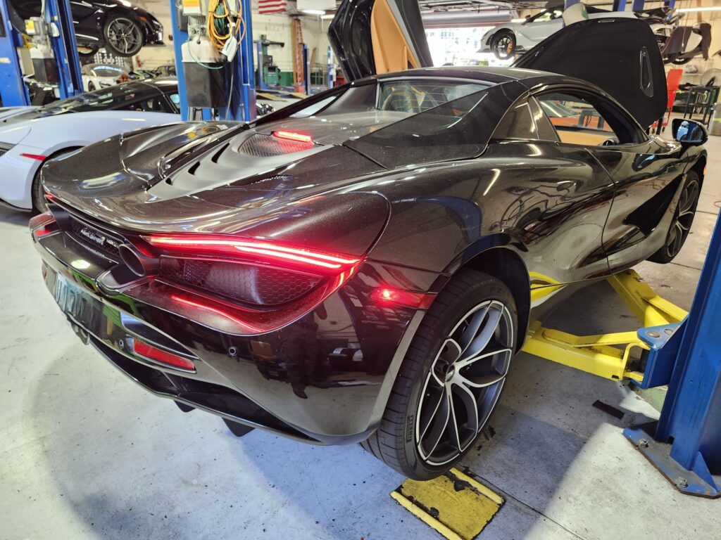 A 2020 McLaren 720S on a lift in Palm Beach, highlighting why the car’s accident record permanently impacts the overall supercar depreciation curve.