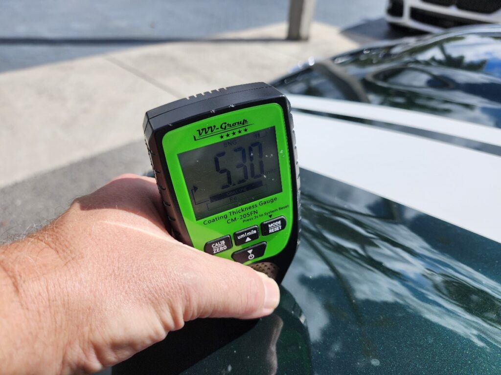 Using a precision paint detph gauge during an independent car appraisal to measure the trade in value after accident impact.