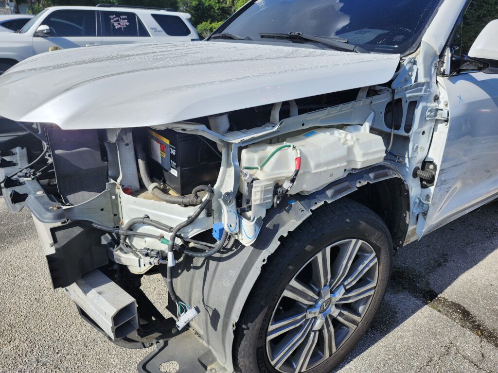 Independent auto appraiser inspecting structural damage and front end disassembly on a Lexus SUV during a diminished value appraisal in Margate FL