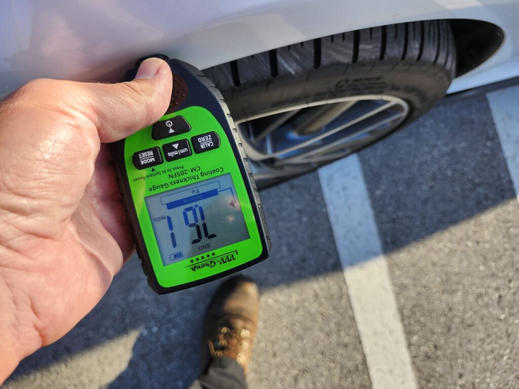 A technical tool measuring paint thickness during a diminished value appraisal report to identify non-factory refinishing.