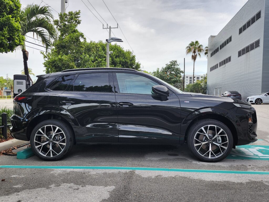 Black Audi electric SUV charging at a Blink station in Fort Lauderdale, evaluated for total loss appraisal value