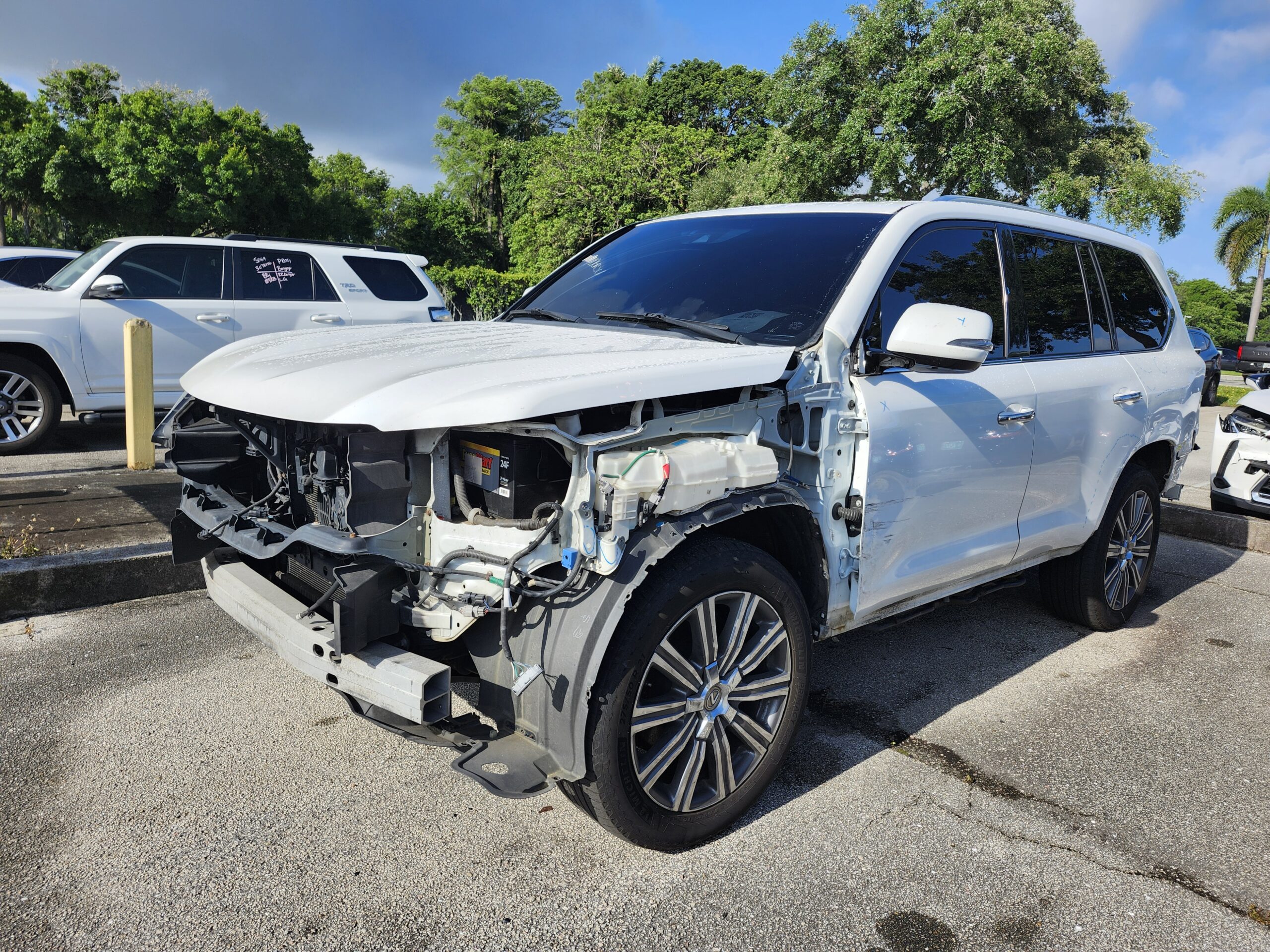 White Lexus LX SUV with catastrophic front-end collision damage exposing engine bay photographed for independent total loss appraisal in Fort Lauderdale
