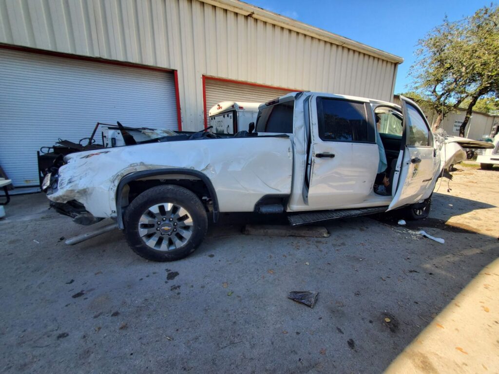 White 2022 Chevrolet Silverado crew cab truck with severe side and door damage evaluated for total loss appraisal