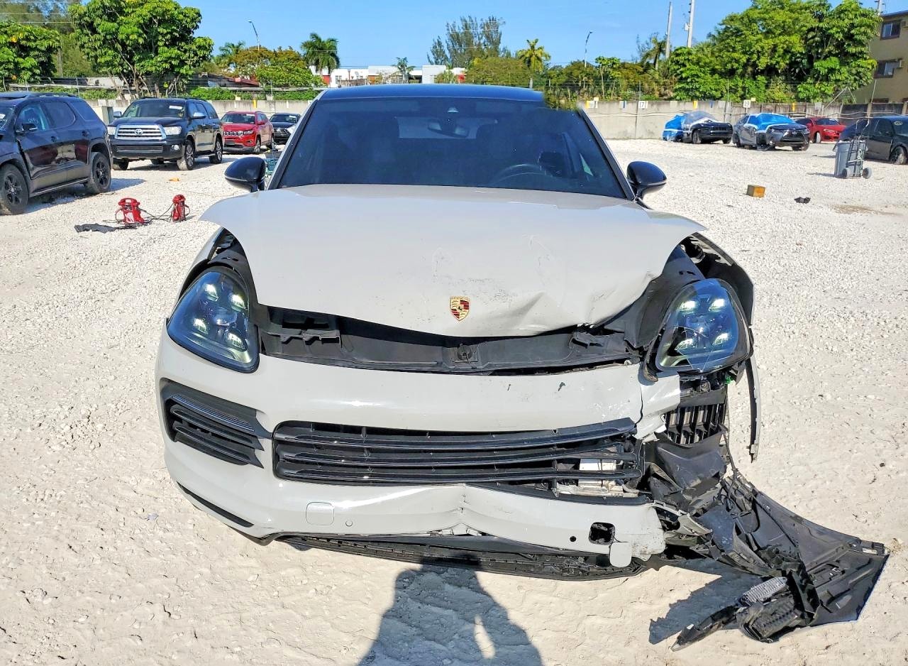 Porsche Cayenne SUV with severe front-end collision damage and detached bumper for total loss appraisal in Orlando