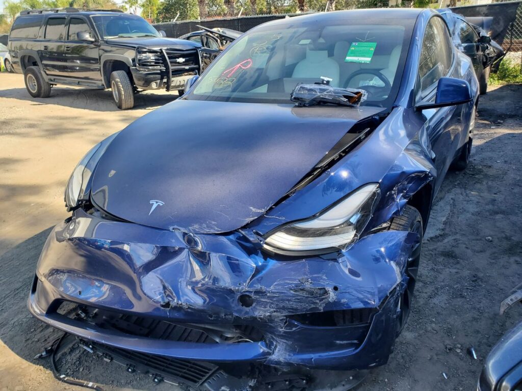 Blue 2021 Tesla Model Y with front-end collision damage being evaluated for diminished value claim