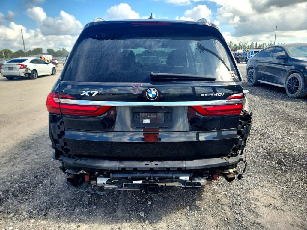 Rear view of black BMW X7 with damaged bumper and exhaust, reviewed for total loss appraisal in Boca Raton, Florida