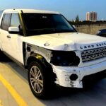 White 2012 Land Rover LR4 with severe front passenger side collision damage photographed in Doral Florida for total loss appraisal