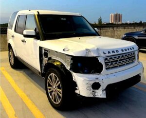 White 2012 Land Rover LR4 with severe front passenger side collision damage photographed in Doral Florida for total loss appraisal