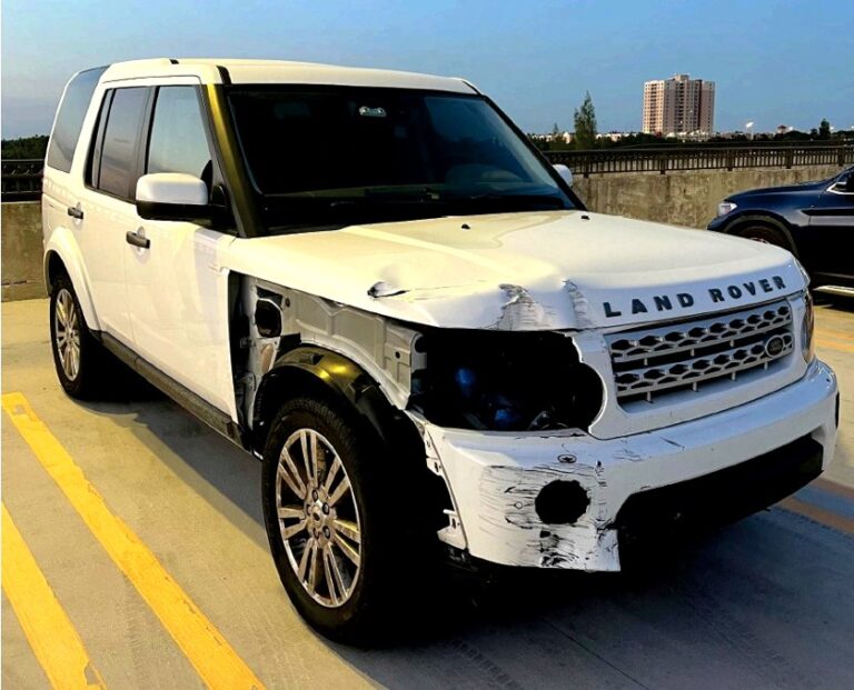 White 2012 Land Rover LR4 with severe front passenger side collision damage photographed in Doral Florida for total loss appraisal