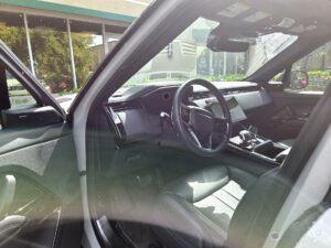 Interior view of white Range Rover dashboard and steering wheel during total loss appraisal in Doral, Florida