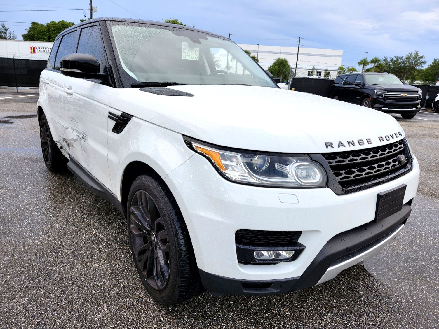 2016 Range Rover Sport with driver side door damage and black wheels photographed in Jupiter Florida for total loss appraisal