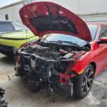 Red Honda Civic Sport with severe front-end collision damage and exposed engine bay in Royal Palm Beach for total loss appraisal