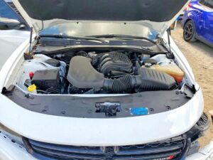 Engine bay of a white 2023 Dodge Charger inspected during total loss appraisal in Sarasota, Florida