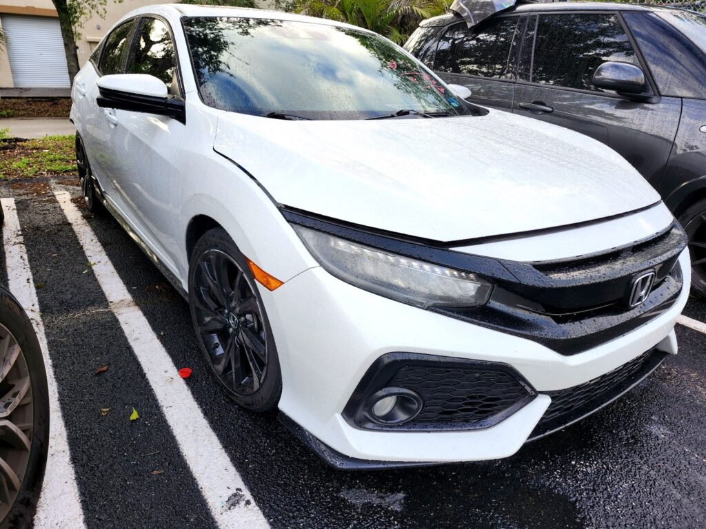 White Honda Civic hatchback with front bumper damage, inspected for total loss appraisal in Weston, Florida