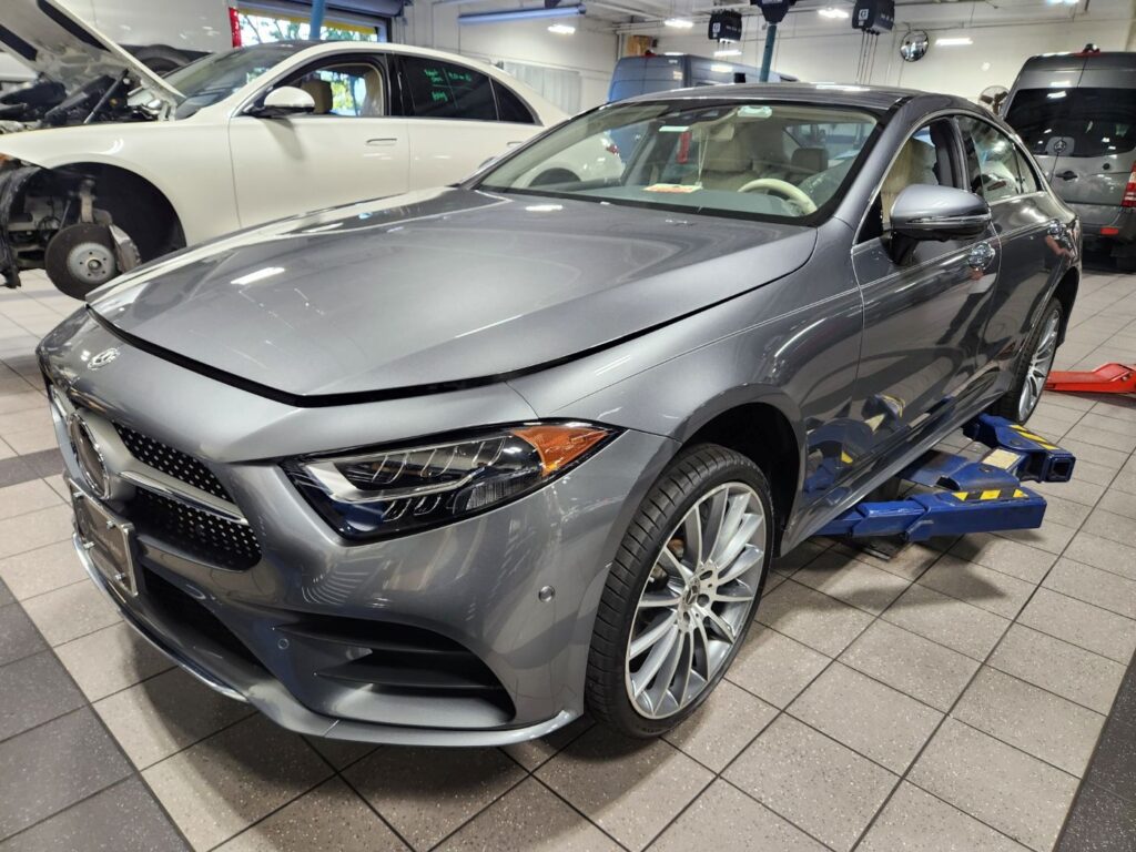 Gray Mercedes-Benz CLS450 on an alignment rack in a repair facility, photographed for a diminished value appraisal in West Palm Beach, Florida