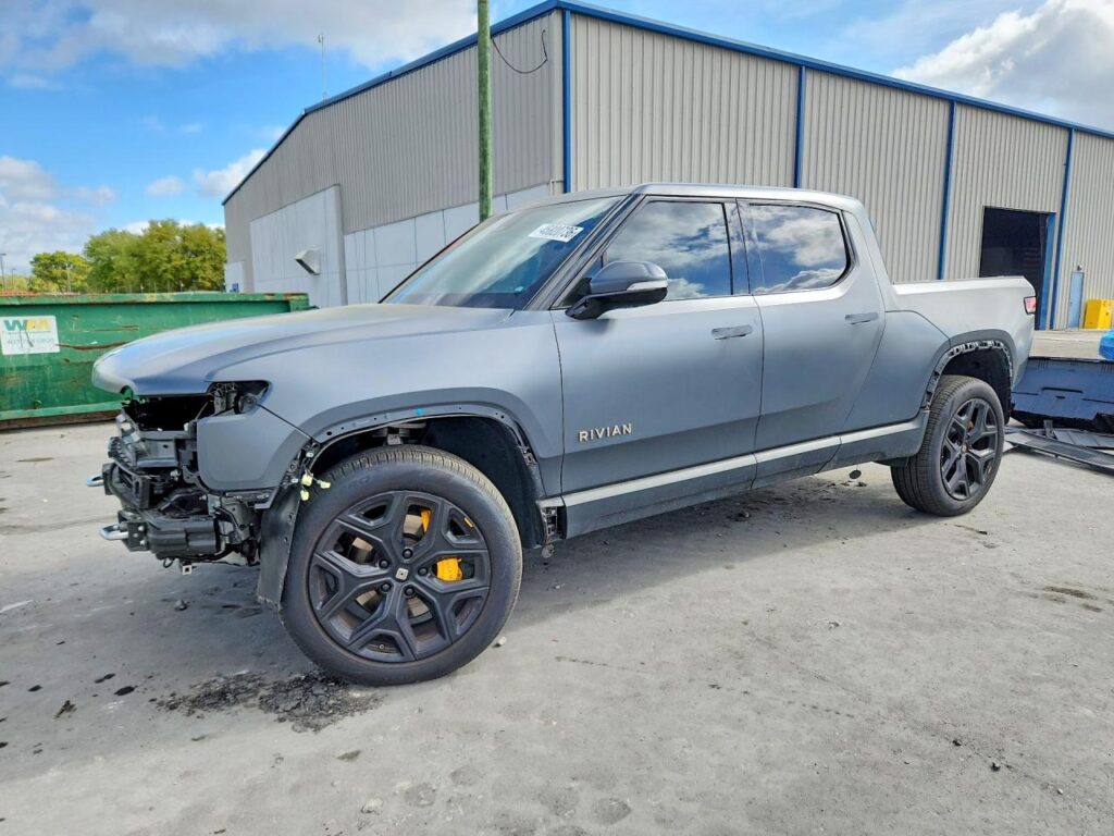 Gray Rivian R1T pickup with front-end collision damage, photographed during a Florida total loss appraisal inspection